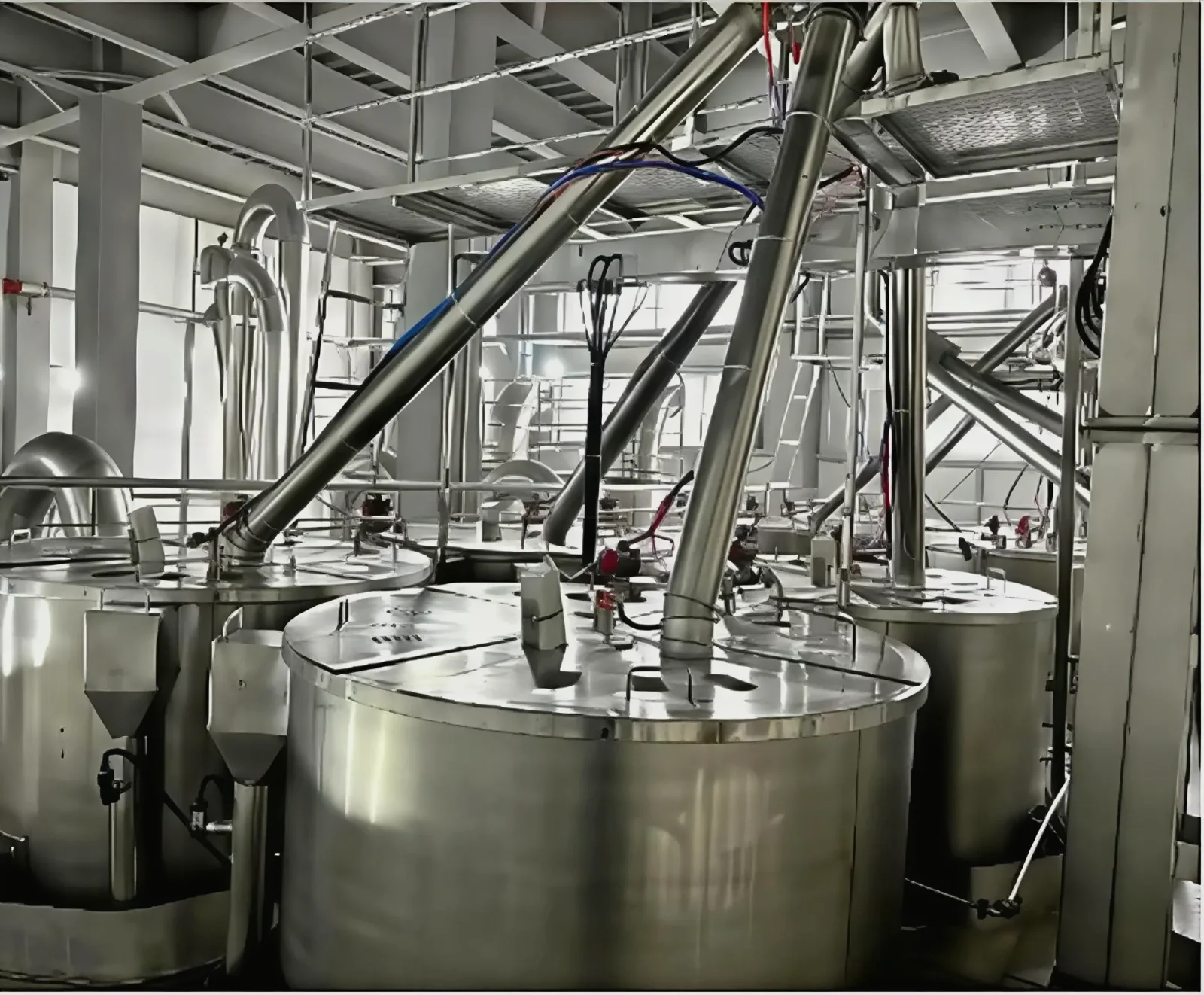 Flexible crushing production line: stainless steel process vessels, access platforms and ducting inside a food-grade workshop.